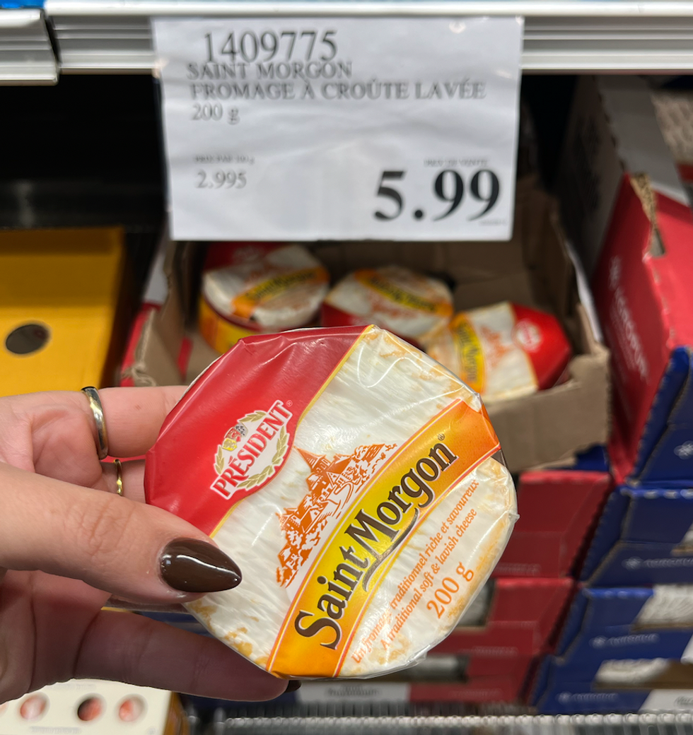 Main qui tient le\u200b fromage Saint Morgon \u00e0 cro\u00fbte lav\u00e9e.