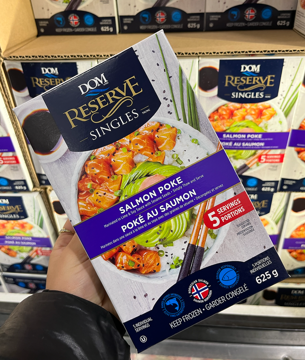 Main qui tient un emballage de 5 portions de Pok\u00e9 au saumon congel\u00e9.