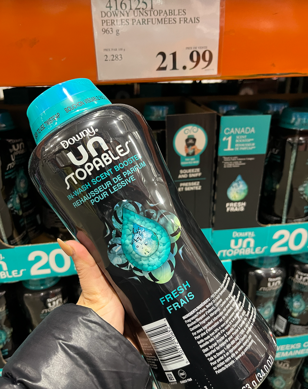Main qui tient une bouteille de perles parfum\u00e9es pour le lavage de marque Downy.