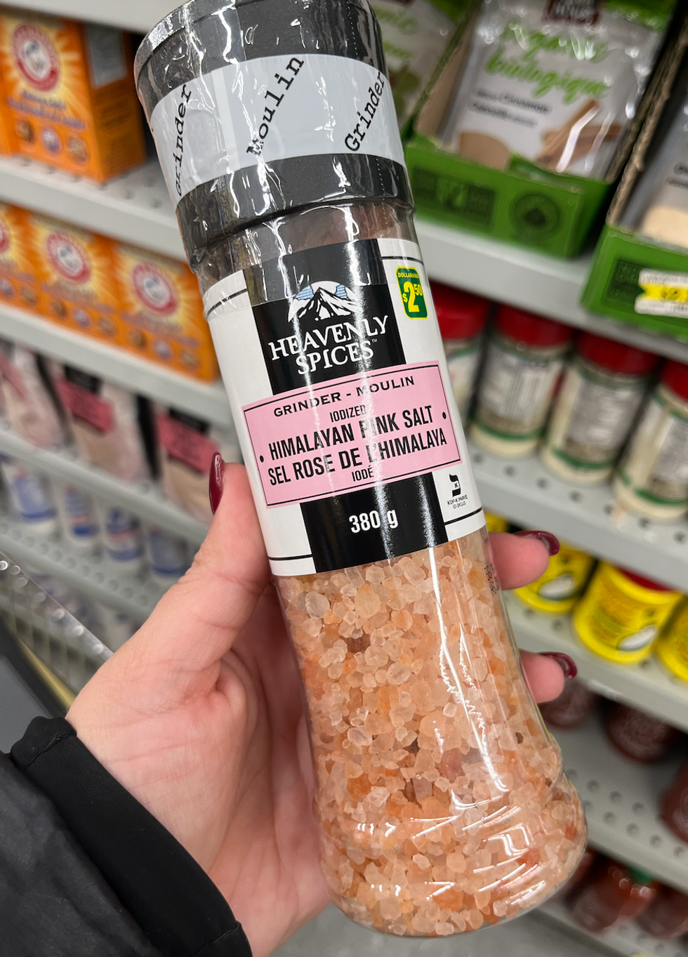 Main qui tient une bouteille de sel rose de l'Himalaya au Dollarama.