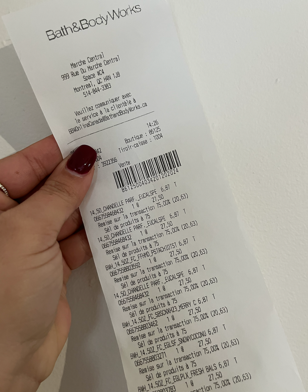 Main qui tient une facture du Bath & Body Works.