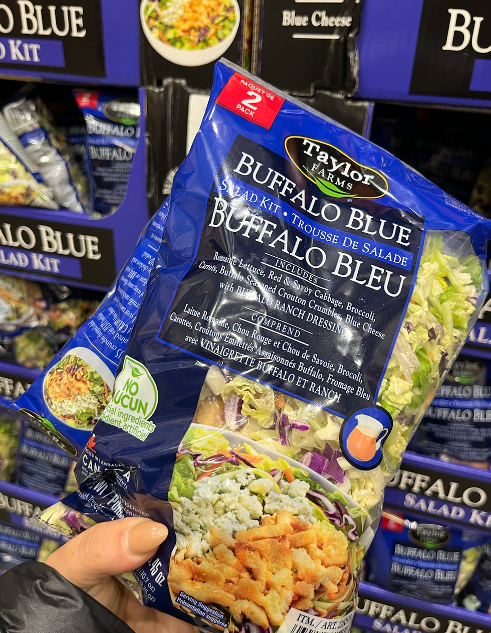 Main qui tient une trousse pour faire une salade repas.