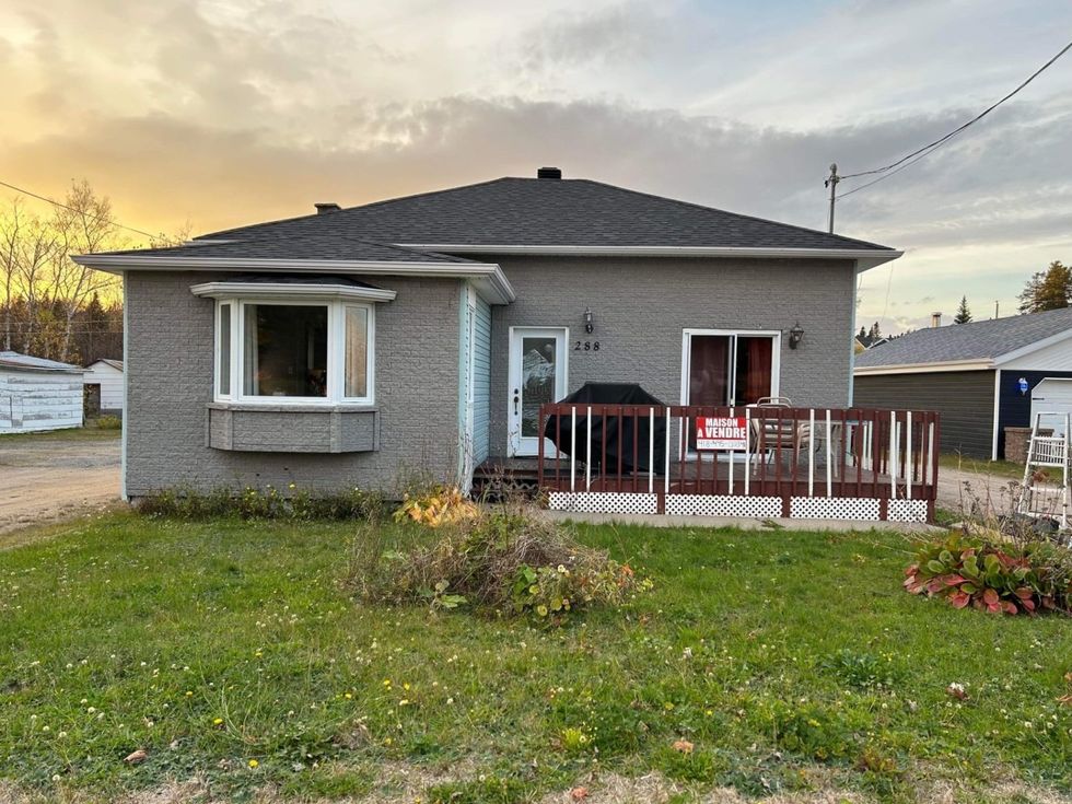 Maison grise avec v\u00e9renda brune \u00e0 vendre au Qu\u00e9bec.