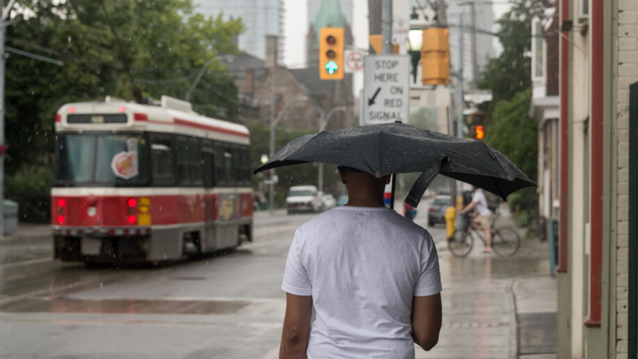 Man holding umbrella in Toronto.