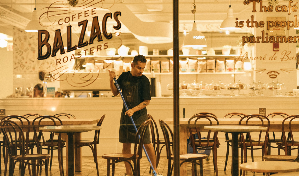 man mopping floor of coffee balzacs roaster