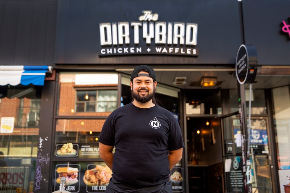 Man standing in front of restaurant.