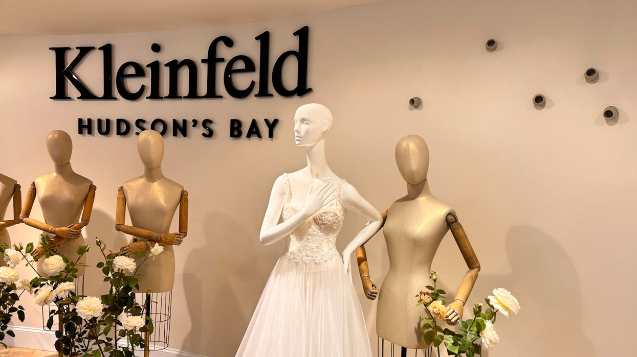Mannequins against a white wall with a mannequin wearing a white bridal dress.