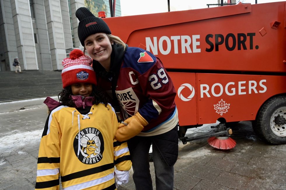 Marie-Philip Poulin et une jeune fille posent ensemble devant la Zamboni de Rogers.