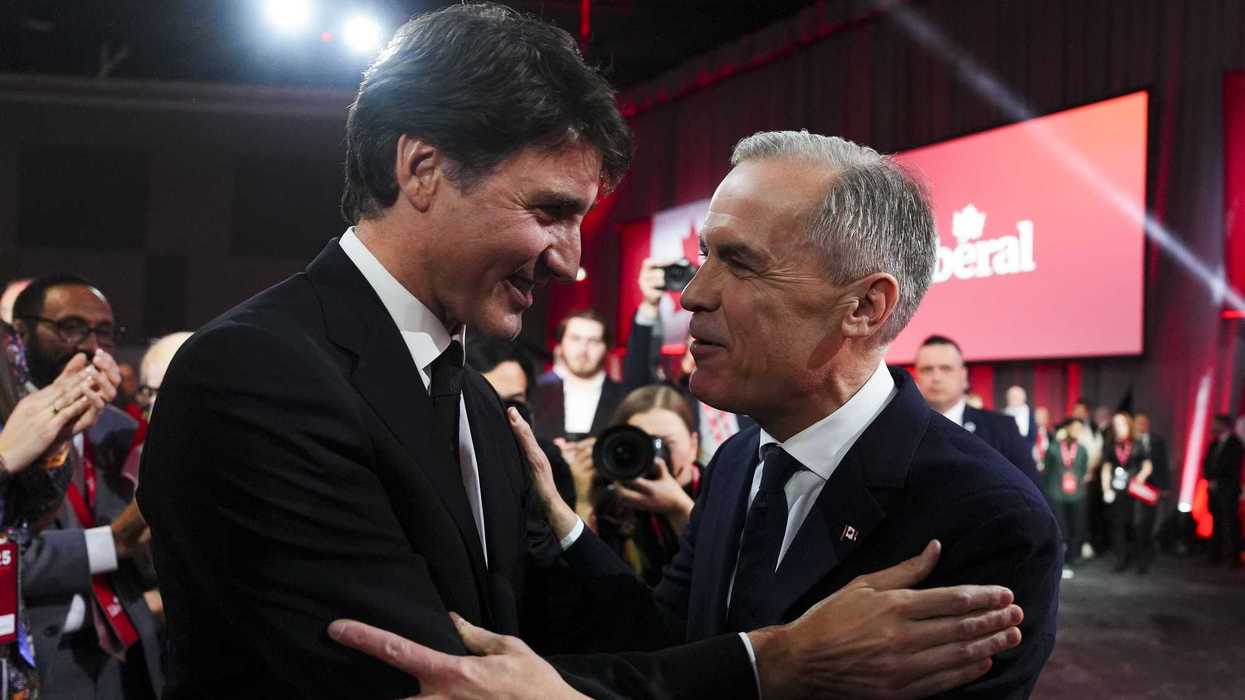 Mark Carney and Justin Trudeau speak and embrace at a Liberal convention.