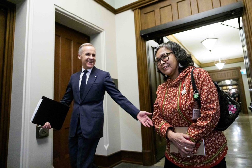 Mark Carney and Lori Idlout walk through a building on Parliament Hill.