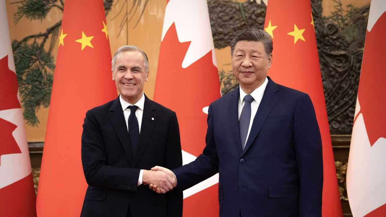 Mark Carney shakes hands with Xi Jinping.