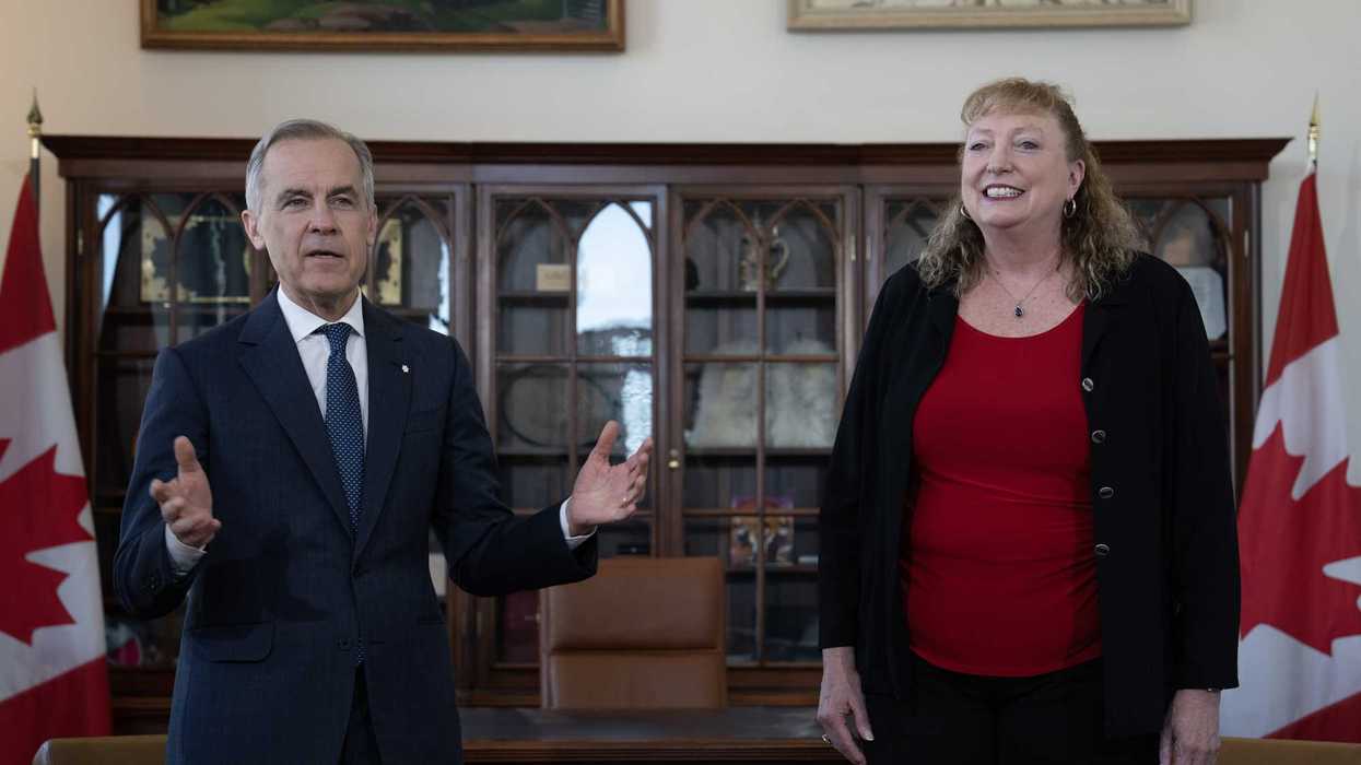 Mark Carney speaks about Marilyn Gladu as she looks on during an event in his office.