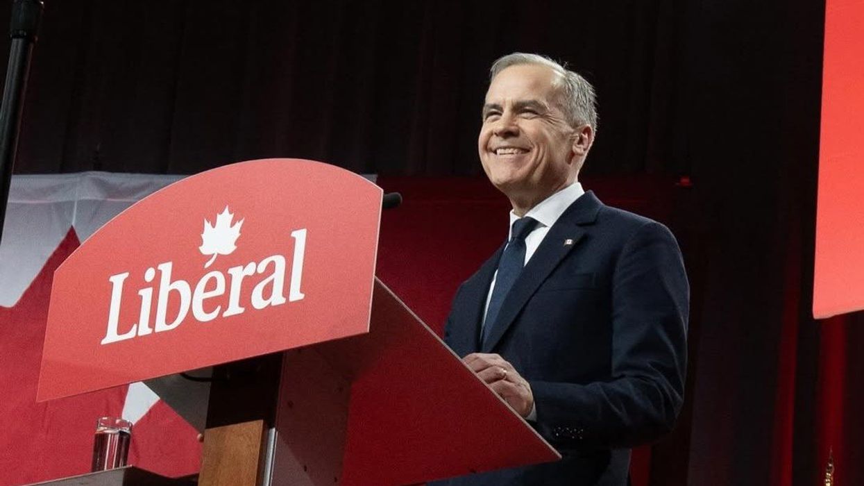 mark carney standing at a podium with a liberal party sign on it