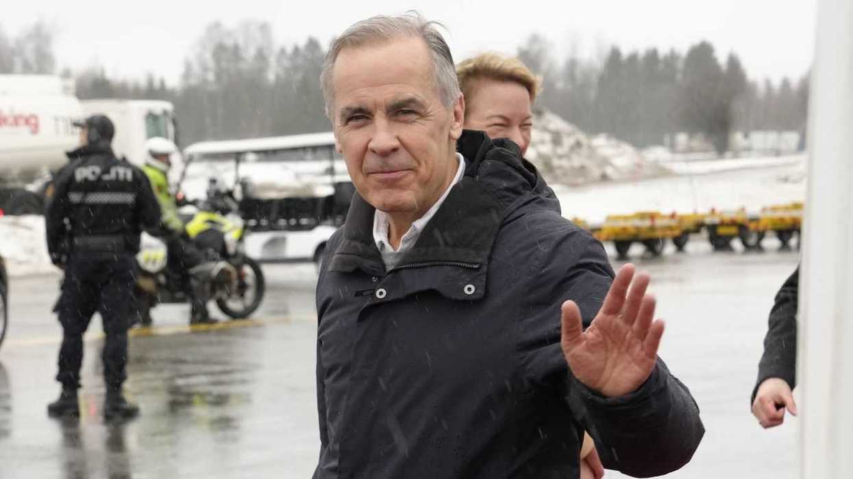Mark Carney waves to camera after stepping off a plane in Oslo.