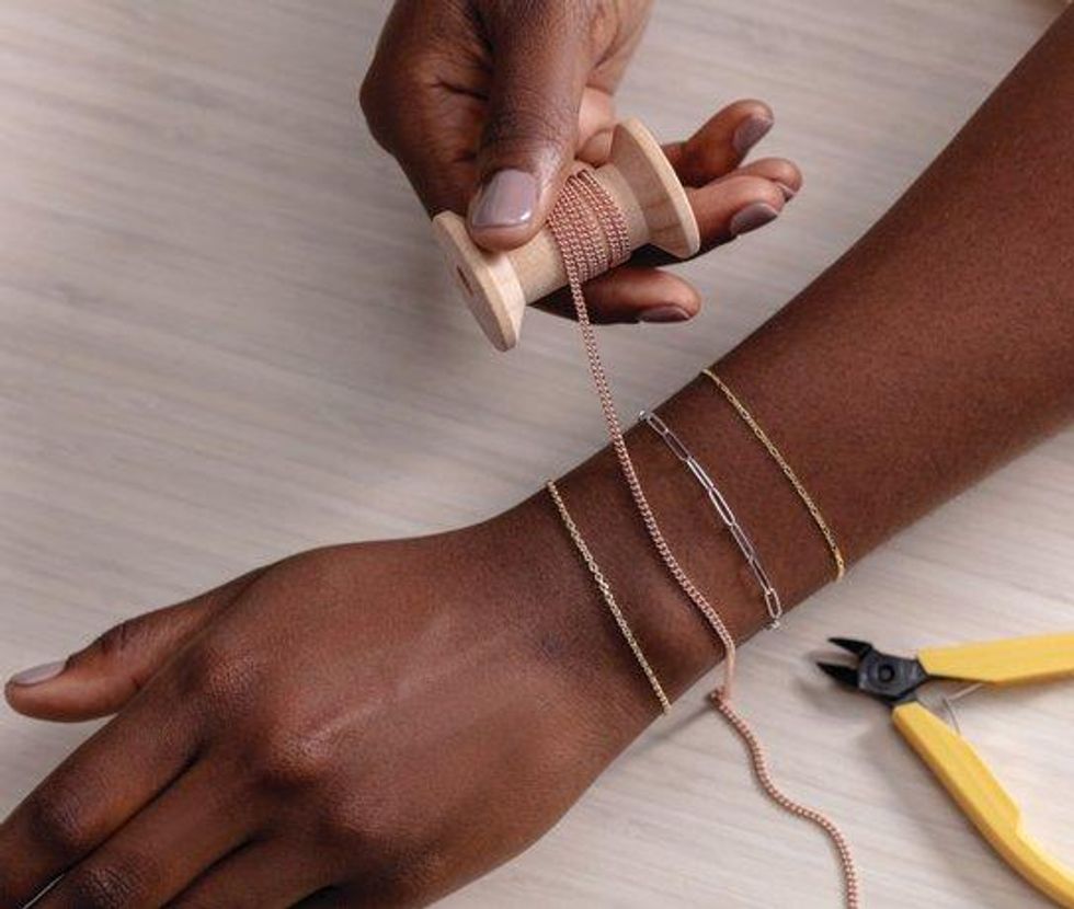 Measuring a permanent bracelet chain on a woman's wrist.