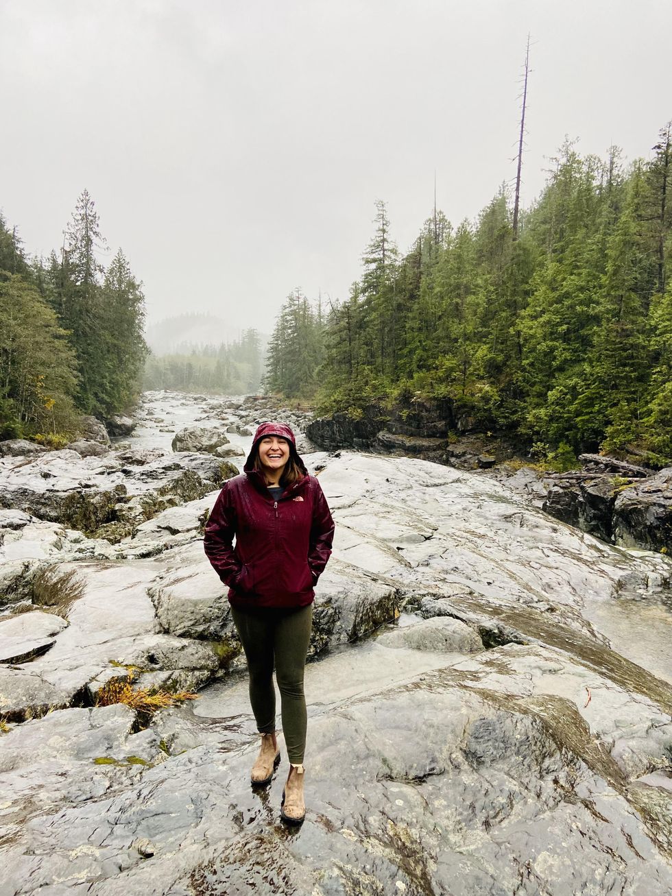 Megan in a Tla-o-qui-aht Tribal Park surrounded by evergreens.