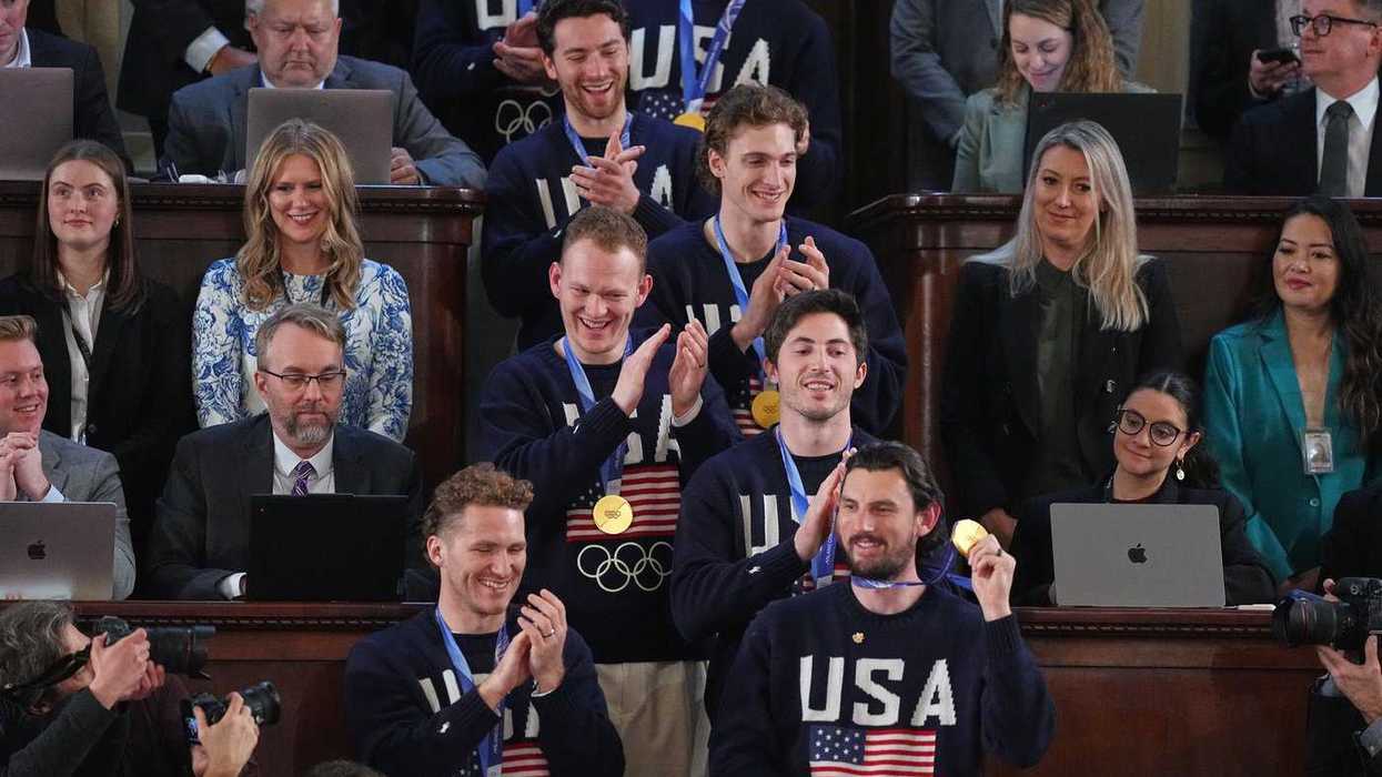 Members of the US Olympic hockey team applauding in the House chamber at the U.S. Capitol.