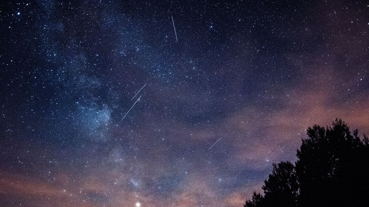 Meteors streaking across a starry sky at night.