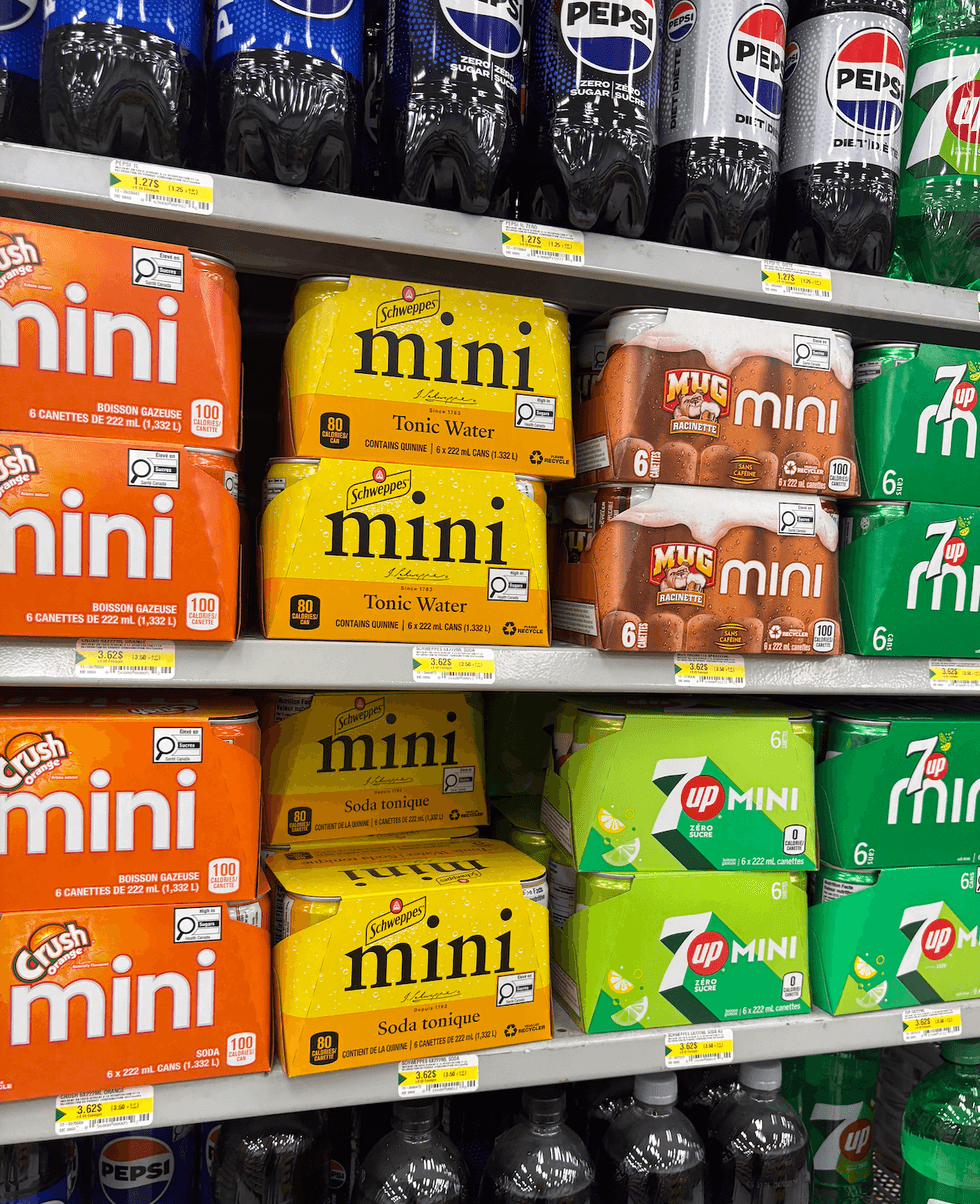 Mini canettes de boissons gazeuses sur les tablettes du Dollarama.