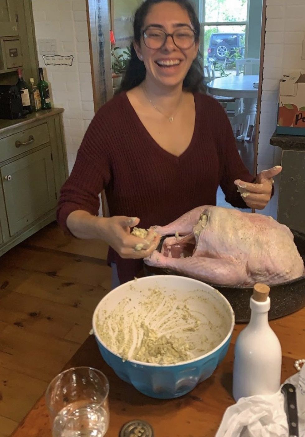 Mira hands deep in a turkey.