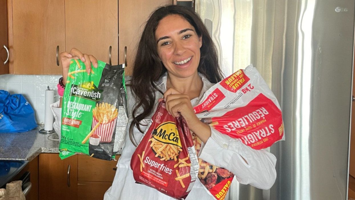 Mira holding bags of frozen French fries from a grocery store.
