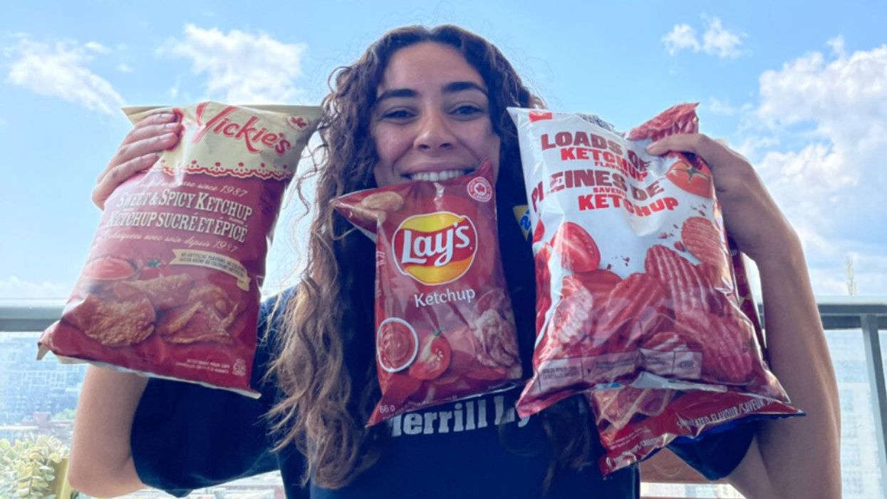 Mira holding bags of ketchup chips.