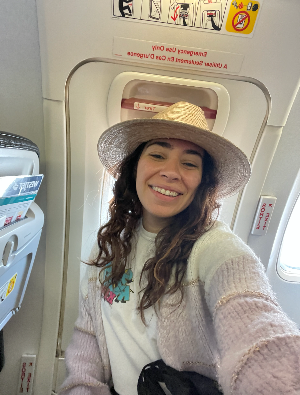 Mira sitting in the emergency exit row on a WestJet flight.