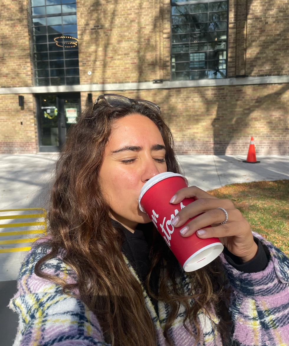 Mira taking a sip from her double-double.