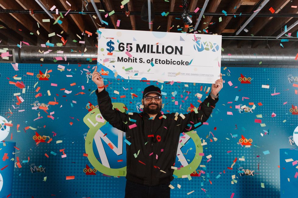 mohit sharma holding a $65 million lotto max cheque
