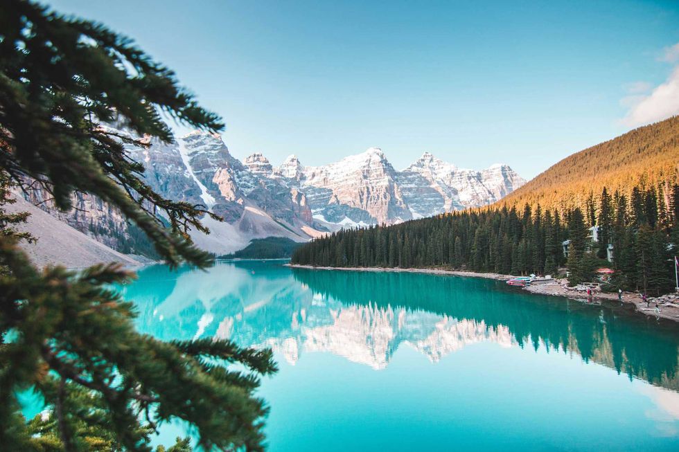 Moraine Lake's turquoise water in front of mountains and forest.