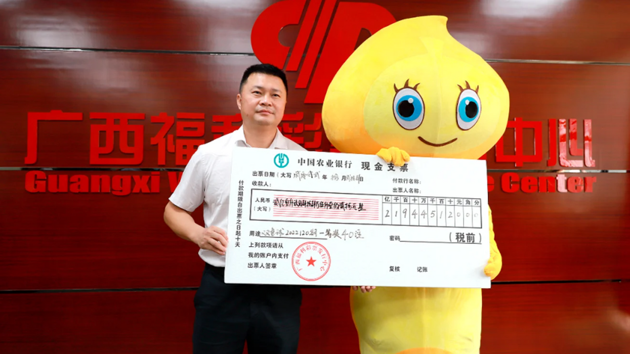 "Mr. Li" stands in a costume at the Guangxi Welfare Lottery Distribution Center after winning the lottery.