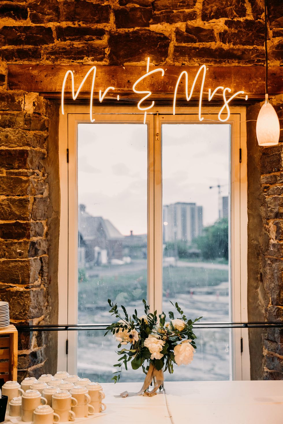 Mr. & Mrs. neon sign over the dessert table at a wedding.