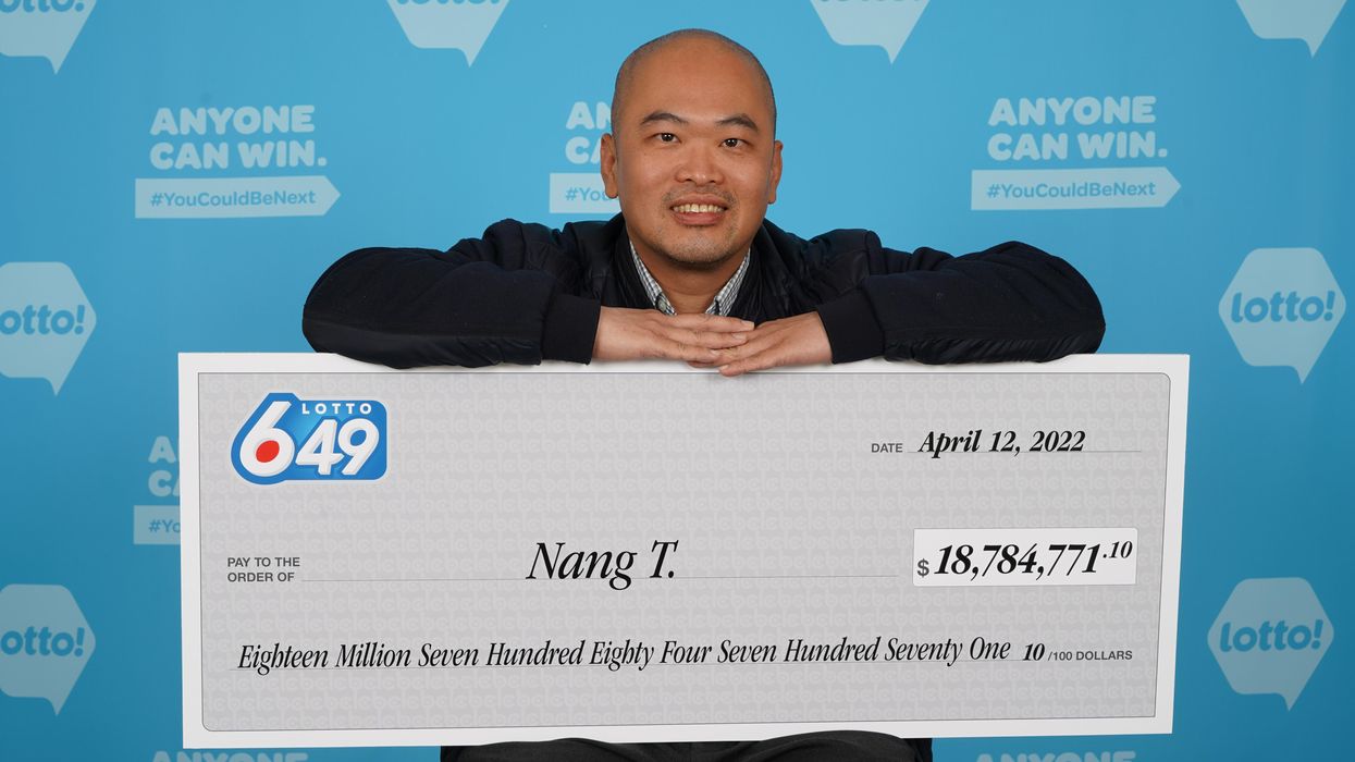 Nang (Paul) Trinh holding his Lotto 6/49 cheque for $18.7 million.
