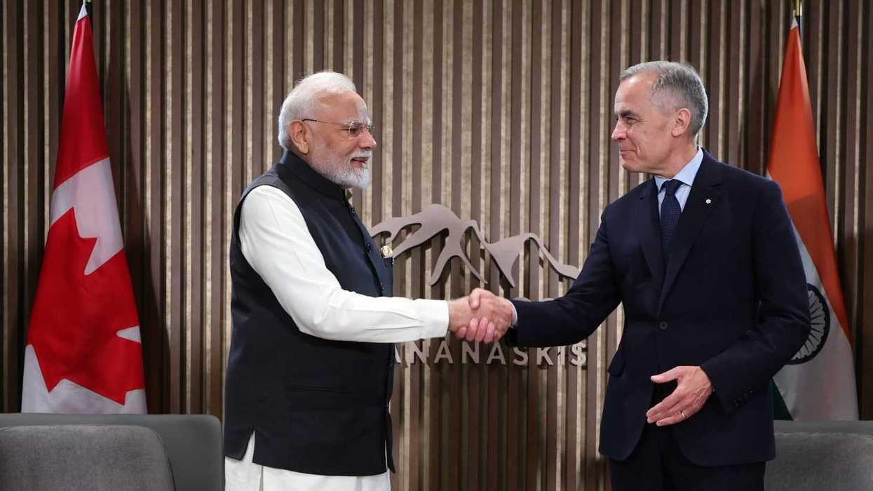 Narendra Modi and Mark Carney shake hands.
