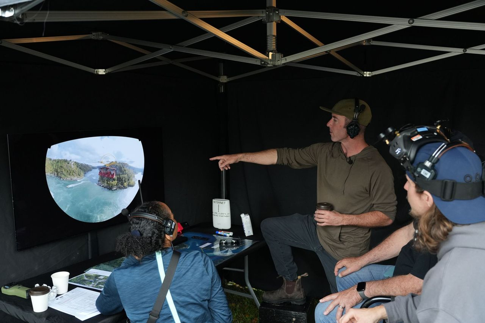 "Niagara Takes Flight" crew review drone footage inside a tent at the filming location.