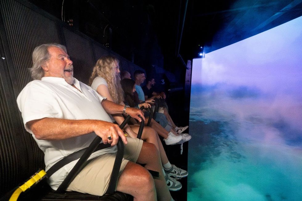 "Niagara Takes Flight" guests in a row marvel at the giant screen while suspended in a gondola.