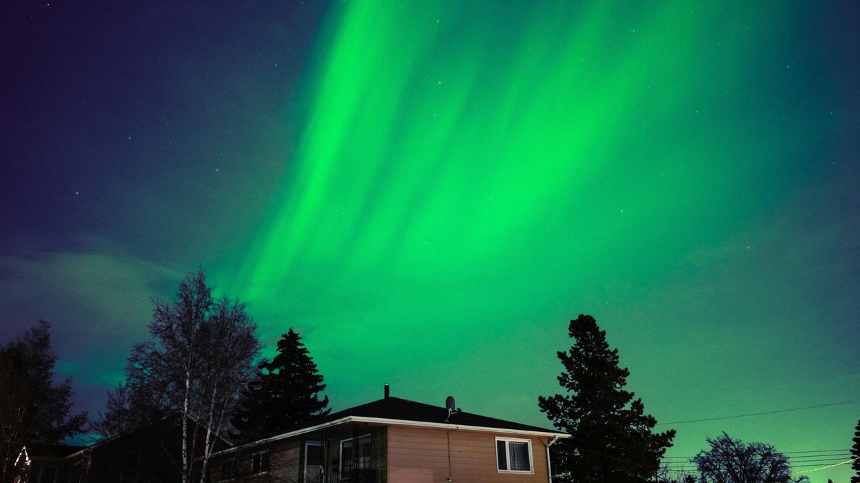 northern lights in the night sky above a house in calgary