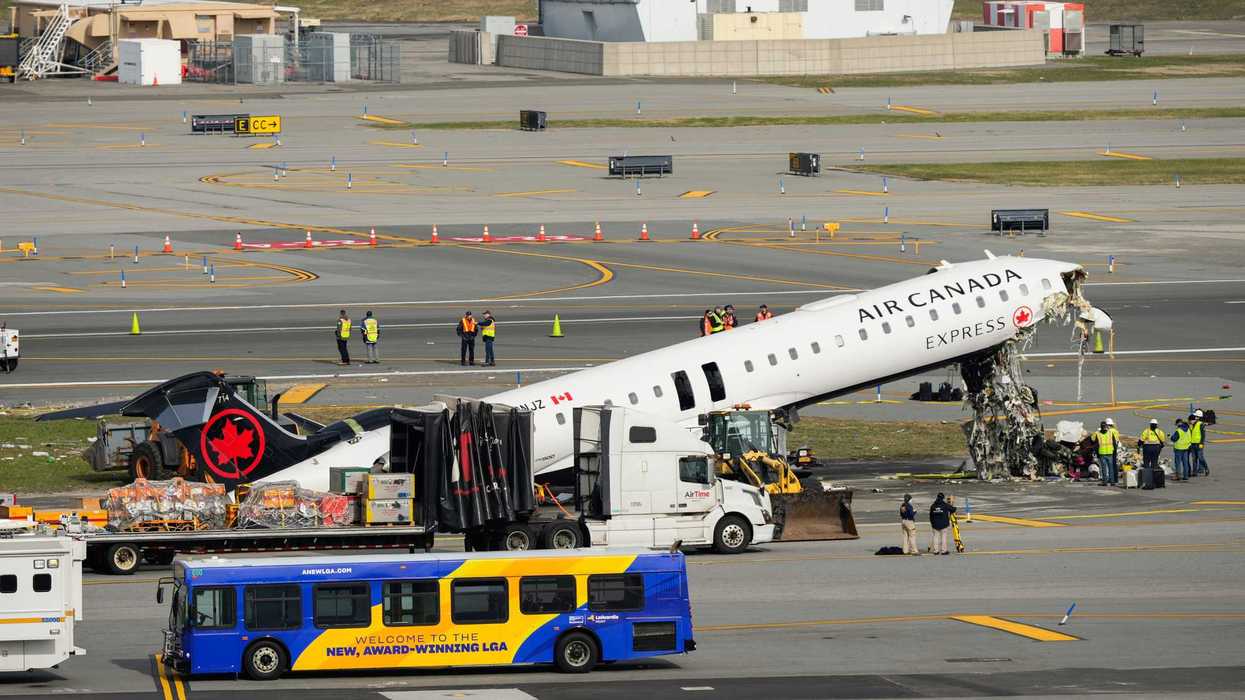 Officials inspect the wreckage of an Air Canada Express jet.