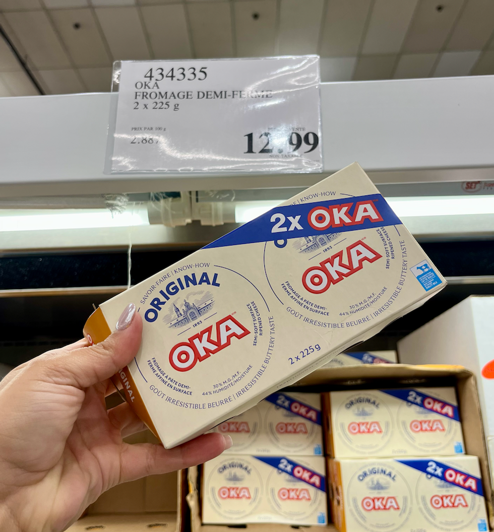 OKA \u00e0 p\u00e2te demi-ferme dans une main au Costco.