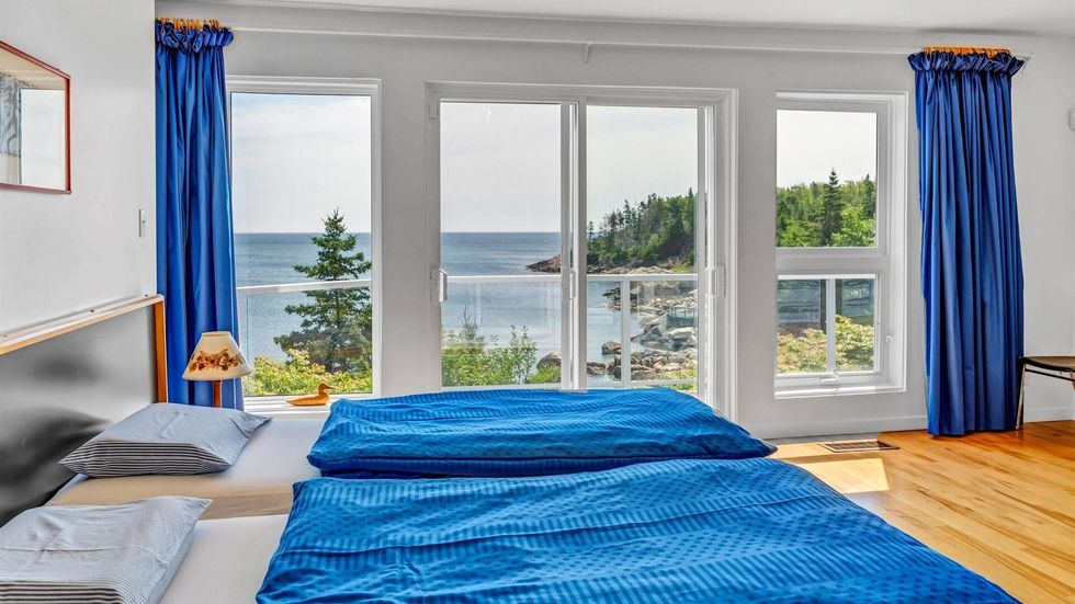 One of the house's bedrooms that opens to a deck with views of the ocean.