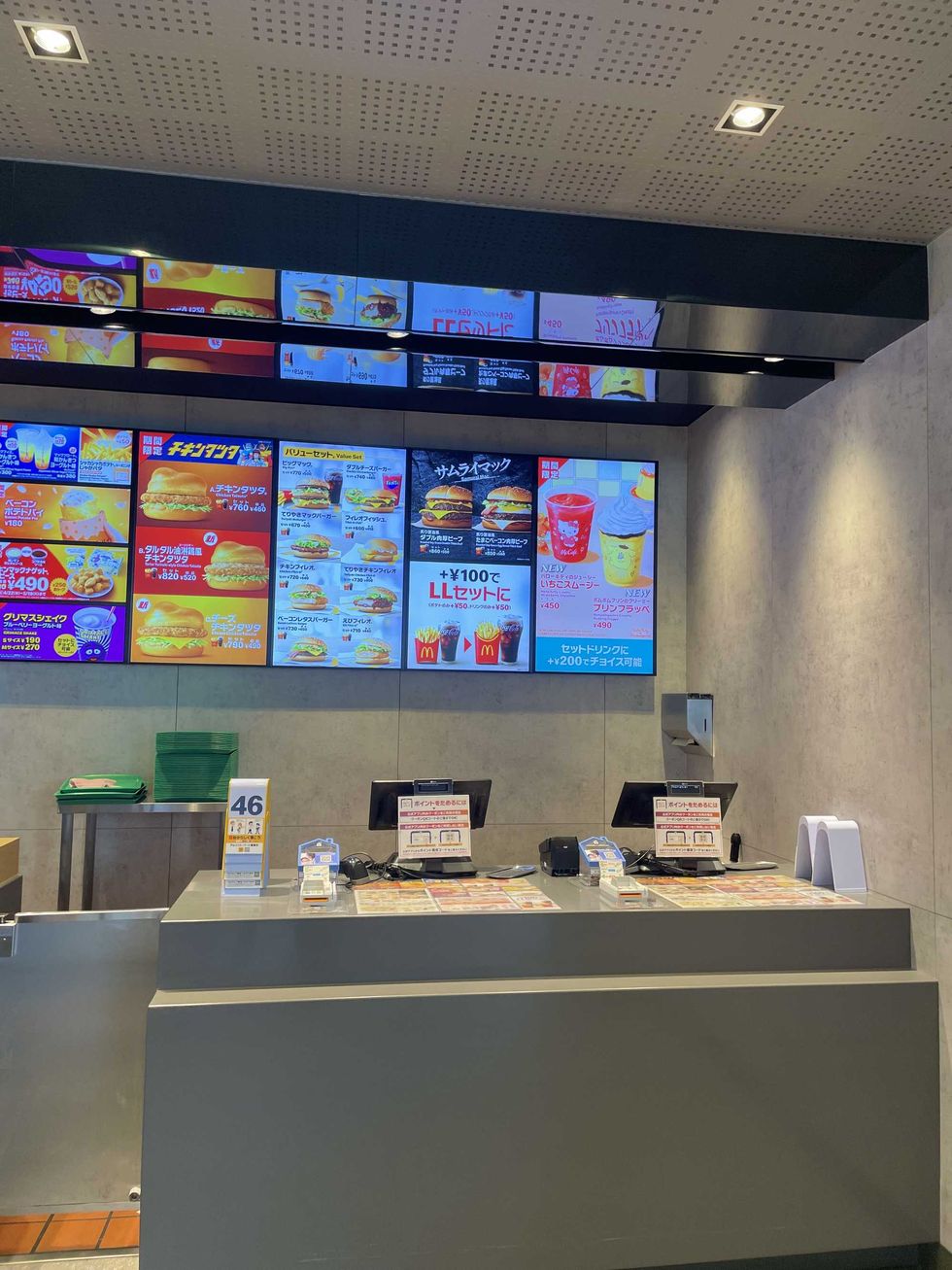 Ordering counter at McDonald's, with several screens of menu options behind.