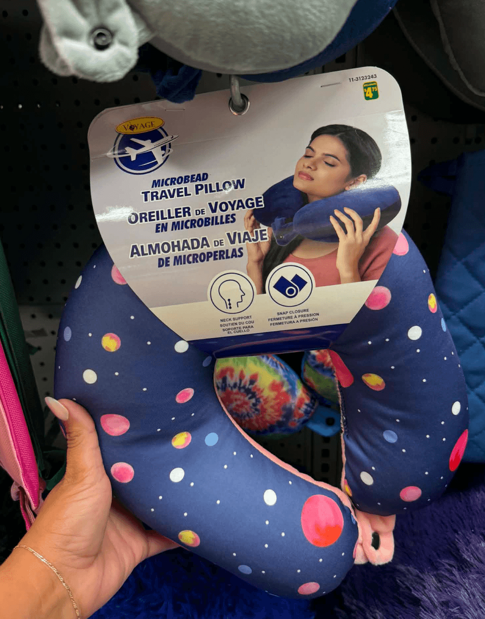 Oreiller de voyage tenu dans une main au Dollarama.