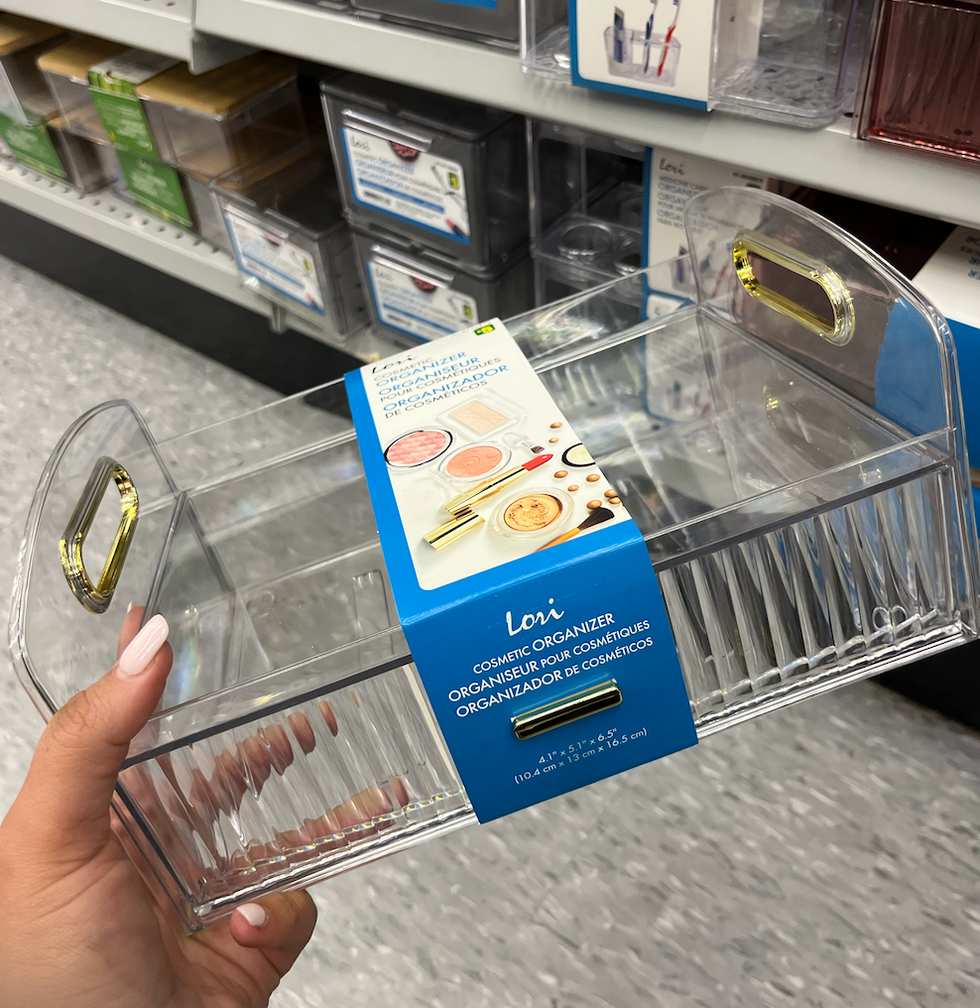 Organisateur de cosm\u00e9tiques transparent dans une main, au Dollarama.