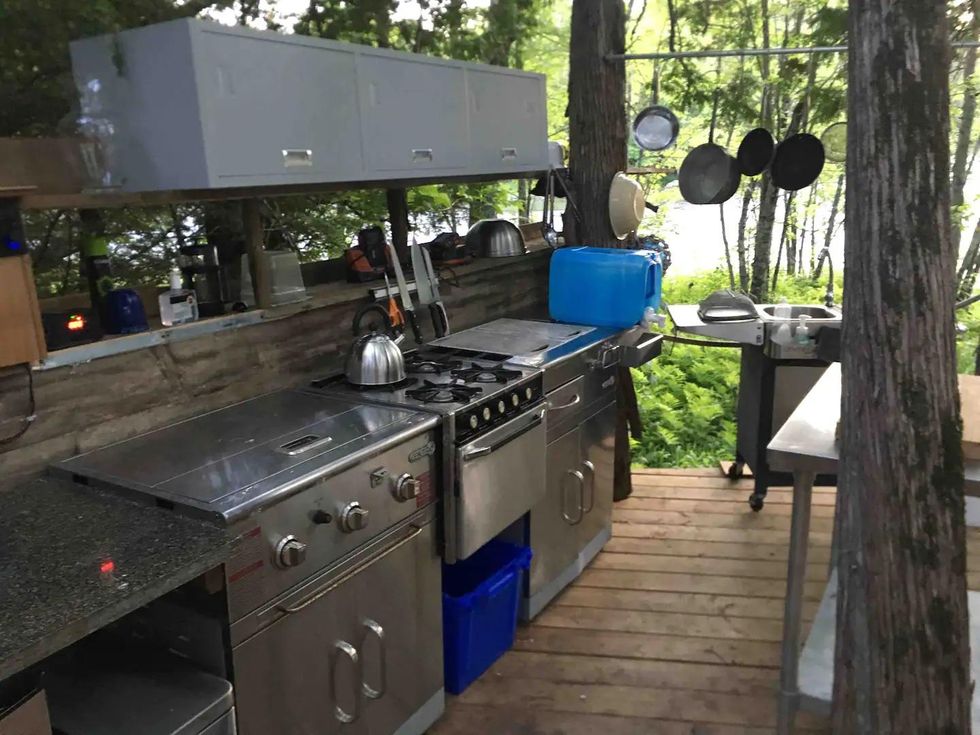 Outdoor kitchen set up with stove and BBQ on a private island Airbnb.