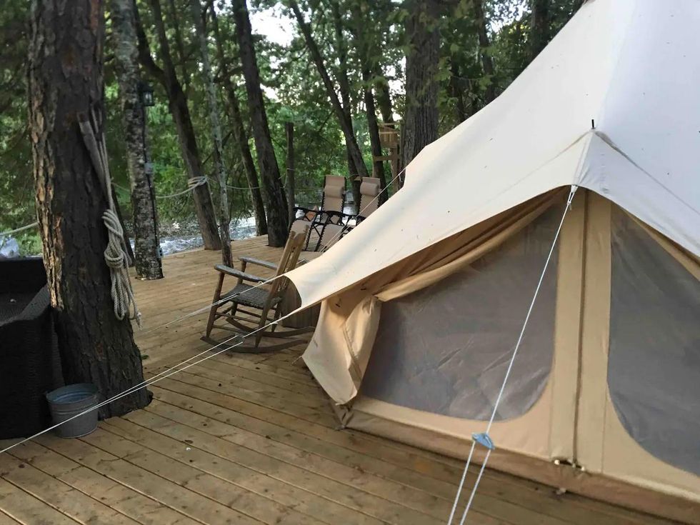 Outdoor view of glamping tent, seating areas and trees on private island in Ontario.
