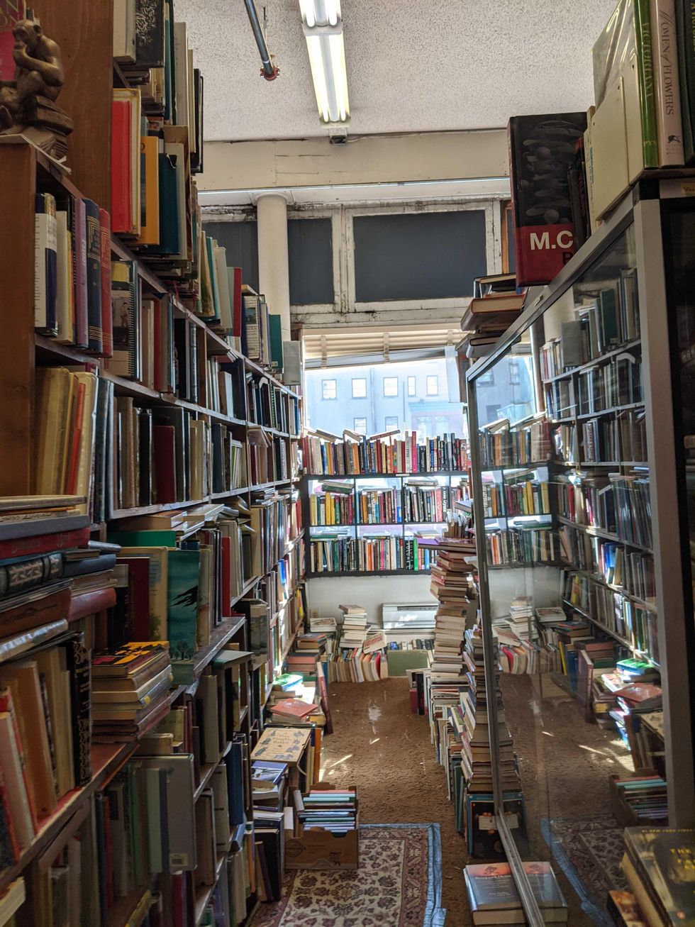 Overflowing bookshelves with books lining the floors and walls.