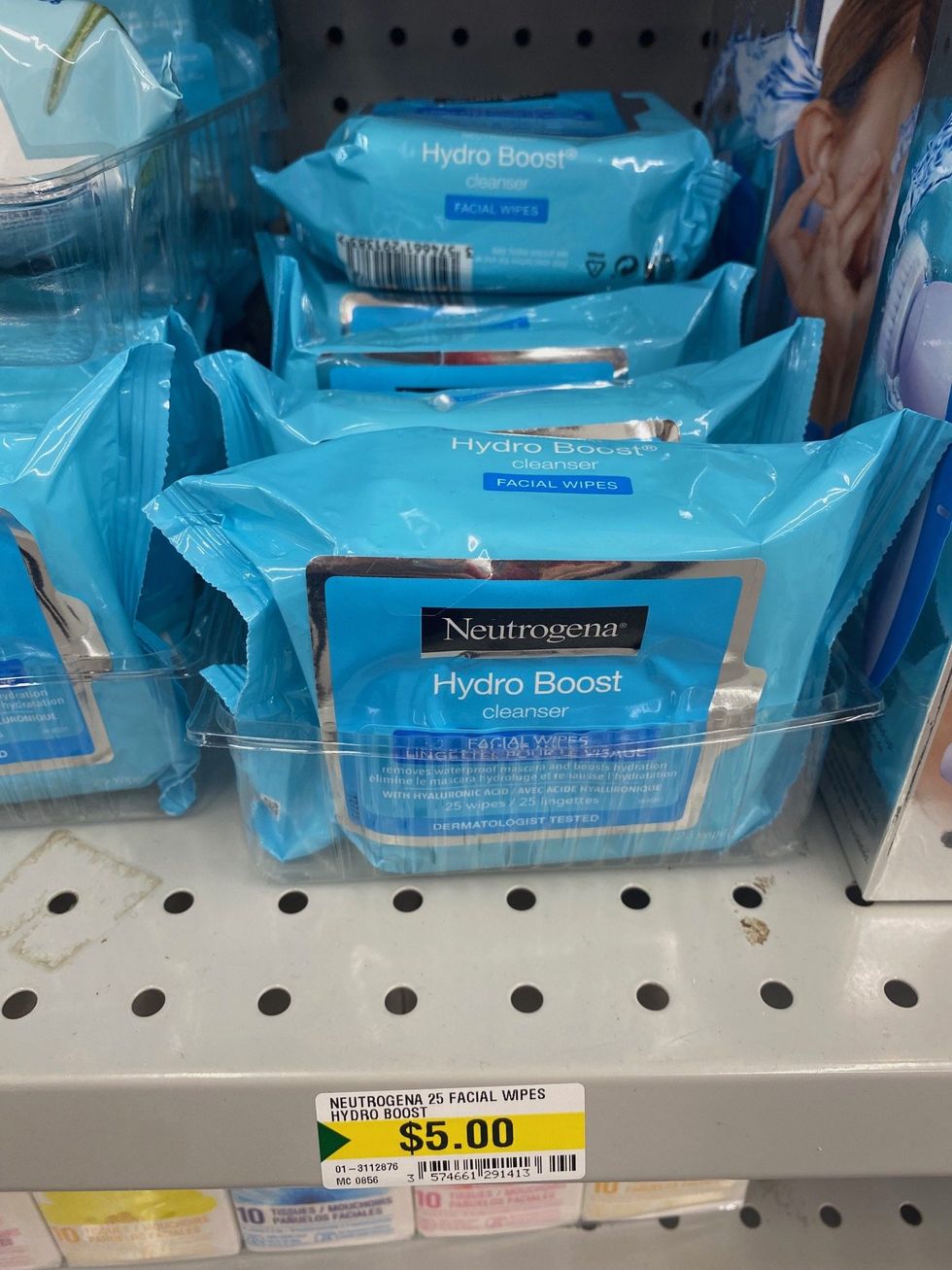Packs of blue coloured make-up removing face wipes on a store shelf.