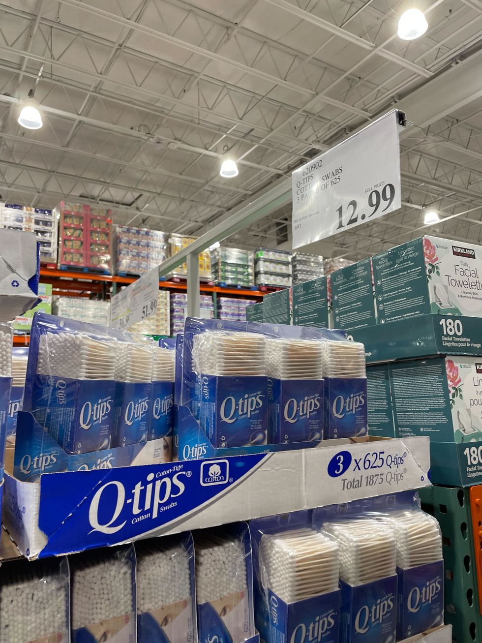 packs of q-tips stacked on a shelf at costco