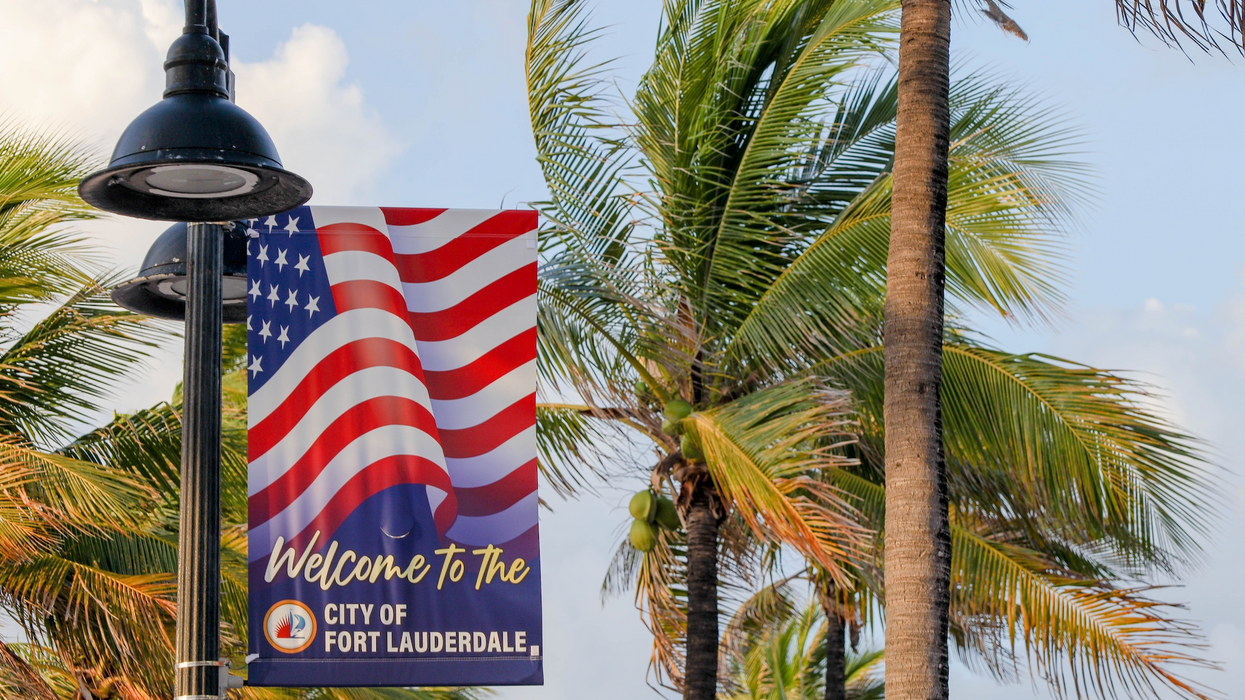 Pancarte de bienvenue « Welcome Flag » à Fort Lauderdale devant les palmiers en Floride.