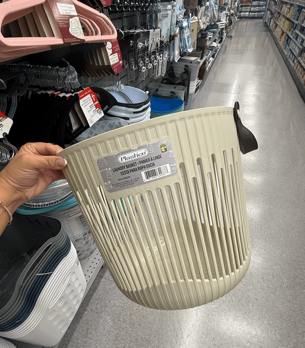 Panier \u00e0 linge beige en plastique avec design ajour\u00e9 et ganse brune en similicuir, vendu 4,50 $ chez Dollarama.